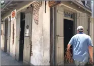  ?? (AP/Kevin McGill) ?? A worker carries equipment Friday into Lafitte’s Blacksmith Shop, a bar on Bourbon Street in New Orleans. More photos at arkansason­line.com/614orleans/.