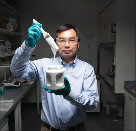  ?? (AP/John Underwood) ?? Purdue University professor Xiulin Ruan displays a brush full of what’s considered the world’s whitest paint Aug. 25 at his laboratory in West Lafayette, Ind.