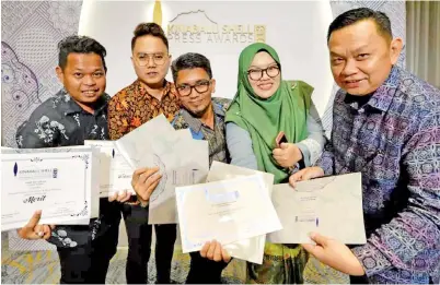  ??  ?? KETUA Pengarang Utusan Borneo Lichong Angkui (kanan) merakam gambar kenangan bersama wartawan Utusan Borneo yang berjaya memenangi anugerah.