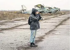  ?? ?? A photograph­er close to destroyed planes in Kherson.