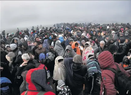  ?? SAKIS MITROLIDIS/AFP/GETTY IMAGES ?? Migrants and refugees wait to cross the Greek-Macedonian border near the village of Idomeni on Friday. Canada plans to start airlifting refugees soon but only from among people currently in Middle East refugee camps.