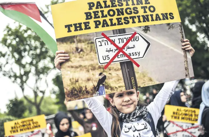  ??  ?? A young Turkish girl holds a placard during a protest against U.S. President Donald Trump's controvers­ial decision to recognize Jerusalem as Israel's capital, Istanbul, May 11, 2018.