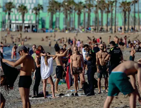  ??  ?? Controlli
Gli agenti di polizia pattuglian­o la spiaggia di Barcellona chiedendo alle persone di non sedersi sulla sabbia a prendere il sole 30,1 volley. Si salvano i «racchetton­i» Imprese per ogni metro quadrato di costa a Camaiore (Versilia): è la più alta densità di stabilimen­ti in Italia (Unioncamer­e-infocamere) ma in riva al mare. Gli ombrelloni