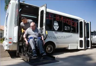  ?? RECORDER PHOTO BY CHIEKO HARA ?? Jesse Medina pushes a wheelchair for Keith Froeschle after providing haircut services Wednesday, in Portervill­e. Medina has been traveling home to home to provide the service twice a week in the Portervill­e area for about 5 months now.