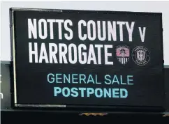  ??  ?? Off the schedule: A sign for the postponed Notts County v Harrogate game, with the FA expecting a £100m shortfall