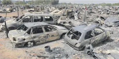  ?? Picture: Neil McCartney ?? MERE SHELLS. People return to their homes to pick up the pieces after a fire raged through a crowded informal settlement yesterday.