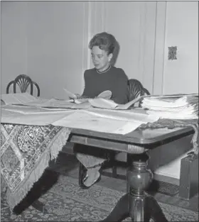  ?? GENE SMITH — THE ASSOCIATED PRESS FILE ?? Bexley, Ohio, housewife Jerrie Mock sits at her dining room table, which has become her workshop for planning her flight around the world, Feb. 29, 1964. Here, she checks out some routes she will follow on her flight.