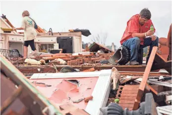  ?? BRANDEN CAMP, AP ?? Jeff Bullard sits in what used to be the foyer of his home as his daughter, Jenny Bullard, looks through debris. Their home was damaged by a tornado on Sunday in Adel, Ga. Gov. Nathan Deal declared a state of emergency in seven counties throughout the...