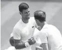  ?? STEVEN PASTON/PA VIA AP ?? Novak Djokovic greets Andy Murray as they practice at the All England Lawn Tennis and Croquet Club in Wimbledon, England, ahead of the tournament, which starts on Monday.