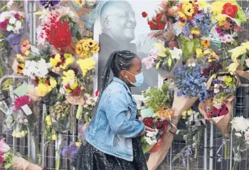  ?? NARDUS ENGELBRECH­T/AP ?? A woman places flowers outside St. George’s Anglican Cathedral on Tuesday in Cape Town, South Africa, where the body of Desmond Tutu will lie in state at the cathedral Thursday and Friday. Tutu, a Nobel Peace Prize-winning activist for racial equality and LGBTQ rights, died Sunday at 90. A funeral service is scheduled for Saturday.