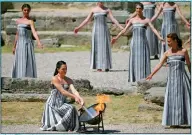  ?? PHOTO: AFP ?? Greek actress Mary Mina lights the torch during the rehearsal of the flame lighting ceremony for the Paris 2024 Olympic Games in southern Greece on April 15.