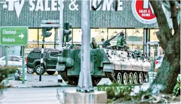  ??  ?? A Zimbabwean army armoured personnel carrier is parked at an intersecti­on in Harare, Zimbabwe. — AFP photo