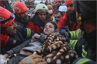  ?? ?? Rescuers carry Muhammed Alkanaas, 12, to an ambulance after he was pulled from a collapsed building late Saturday in Antakya in southern Turkey.
(AP/Can Ozer)