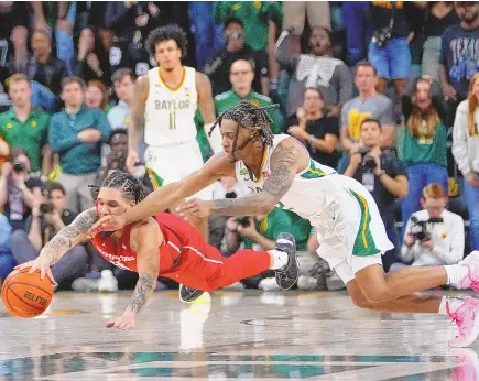  ?? ASSOCIATED PRESS ?? Houston guard Emanuel Sharp, left, and Baylor guard Jayden Nunn compete for a loose ball during overtime of the Cougars’ 82-76 win Saturday in Waco, Texas.