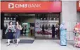  ?? — Reuters ?? People are seen in front of a CIMB Bank office in Kuala Lumpur.