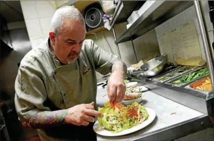  ?? TANIA BARRICKLO-DAILY FREEMAN ?? Frank Jeanetti, the chef at Chops Grille in Uptown Kingston prepares a Chinese Chicken Salad.