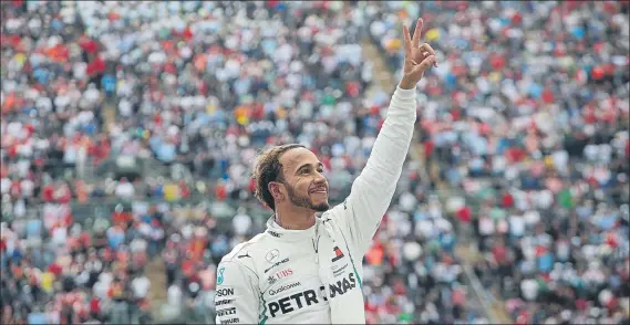  ?? FOTO: AP ?? Lewis Hamilton hace el signo de la victoria tras bajarse de su Mercedes en la zona del Foro Sol después de la carrera de México, ya como nuevo campeón del mundo de Fórmula 1