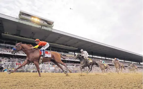  ?? JULIO CORTEZ/ASSOCIATED PRESS ?? Justify (1), with native New Mexican Mike Smith up, crosses the finish line to win the 150th running of the Belmont Stakes on Saturday in Elmont, N.Y. Justify becomes the sport’s 13th Triple Crown champion — and its second in four years.