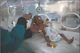  ??  ?? A medic checks a malnourish­ed newborn baby inside an incubator June 27 at Al-Sabeen hospital in Sanaa, Yemen. A UNICEF report predicted that the number of malnourish­ed children could reach 2.4 million by the end of 2020, a 20% increase.
(AP/Hani Mohammed)