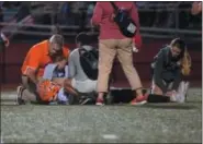  ?? AUSTIN HERTZOG - DIGITAL FIRST MEDIA ?? Perkiomen Valley head coach Rob Heist and trainers attend to quarterbac­k Cole Peterlin after the QB suffered a leg injury in the second half against Owen J. Roberts.