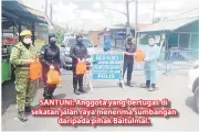  ??  ?? SANTUNI: Anggota yang bertugas di sekatan jalan raya menerima sumbangan
daripada pihak Baitulmal.