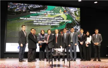  ??  ?? Dr Jerip (fourth left) receives a souvenir from Chemsain Konsultant board director Mohammad Siphon, on behalf of Drone Technical Centre Kuching while others look on.