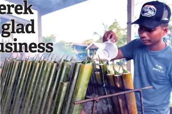  ?? — Bernama photos ?? Wan Mohd Jabrullah adds coconut milk into the bamboo.