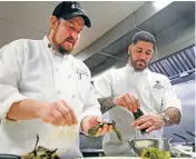  ?? GABRIELA CAMPOS NEW MEXICAN FILE PHOTO ?? Chef Jerry Jeff Dakan, left, and Patrick Mares, chef instructor at Santa Fe Community College, prepare green chile earlier this year at the culinary lab. While enrollment at SFCC is down, Mares said students each semester manage to fill two sections of a culinary fundamenta­ls class.