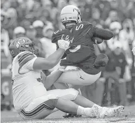  ?? Ronald Martinez / Getty Images ?? Utah’s Lowell Lotulelei drags down West Virginia quarterbac­k Chris Chugunov, who struggled while filling in for the injured Will Grier.