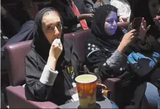  ??  ?? It’s showtime: A Saudi woman eating popcorn at the cinema. — AFP