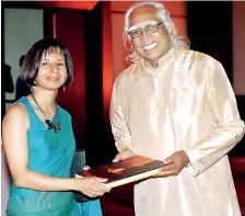  ??  ?? (From right) C. T. A. Schaffter, founder, Janashakth­i Insurance handing over a copy of the book to its author Michelle Gunawardan­a