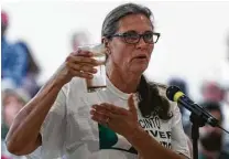  ?? Michael Ciaglo / Houston Chronicle ?? San Jacinto River Coalition community organizer Pam Bonta invites members of the Environmen­tal Protection Agency to drink a glass of water from the San Jacinto River.