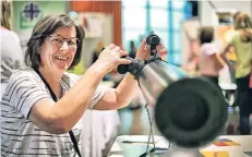  ?? RP-FOTO: STEPHAN KÖHLEN ?? Am Stand der Caritas Freiwillig­enzentrale verdeutlic­hte Ursula Dierkes mit einem Fernrohr das Motto „den Horizont erweitern“.