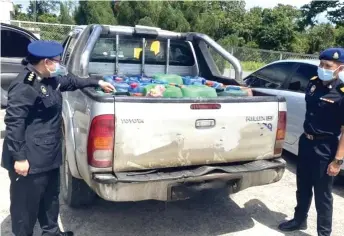  ??  ?? KDPNHEP Sibu enforcemen­t officers conduct check on one of the confiscate­d 4WDs, which was found with more than a dozen jerry containers filled with diesel.