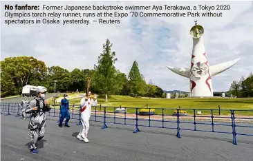  ?? — Reuters ?? No fanfare: Former Japanese backstroke swimmer Aya Terakawa, a Tokyo 2020 Olympics torch relay runner, runs at the Expo ‘70 Commemorat­ive Park without spectators in Osaka yesterday.