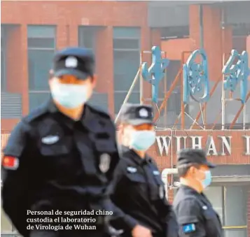  ??  ?? Personal de seguridad chino custodia el laboratori­o de Virología de Wuhan