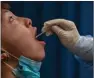  ?? (AFP) ?? A file photo shows a medical worker taking a swab sample from a man to be tested for the COVID-19 coronaviru­s in Wuhan.