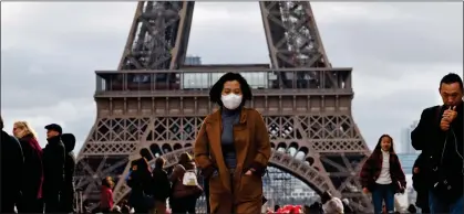  ??  ?? COVERING UP: A woman wears a mask in Paris, where Europe’s first coronaviru­s fatality was confirmed by health officials yesterday