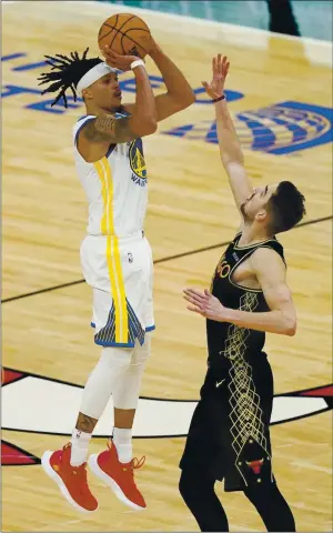  ?? NAM Y. HUH — THE ASSOCIATED PRESS ?? Warriors guard Damion Lee, left, shoots the winning 3-point shot against Chicago Bulls guard Tomas Satoransky during the second half in Chicago on Sunday.