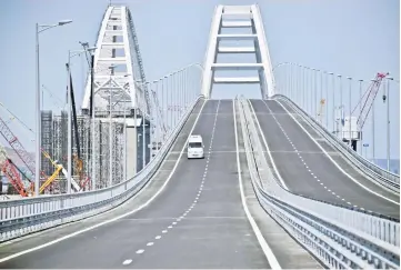  ??  ?? A vehicle runs down the 19 km road-and-rail Crimean Bridge passing over the Kerch Strait and linking southern Russia to the Crimean peninsula yesterday prior to the opening ceremony. — AFP photo