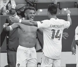  ?? John McCoy Getty Images ?? JONATHAN DOS SANTOS goes shirtless as teammate Javier Hernandez congratula­tes him on his goal against LAFC in the second half of the Galaxy’s 2-1 victory at Dignity Health Sports Park.