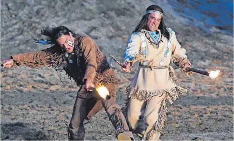  ?? FOTO: BERND BAUR ?? Die Häuptlinge Winnetou und „Schwerer Mokassin“liefern sich im Licht der Dämmerung einen beherzten Kampf mit Fackeln.