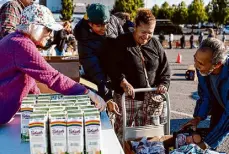  ?? Jessica Christian/The Chronicle ?? Andreas Calix helps his grandparen­ts, Virginia Salgado and Victor Calix, pick out items Nov. 3 during a Redwood Empire Food Bank event in Petaluma.