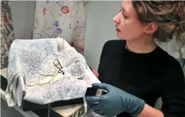  ?? ?? Taking silk: Hannah Daley of the Imperial War Museum with the Countess Mountbatte­n underwear made from an RAF map