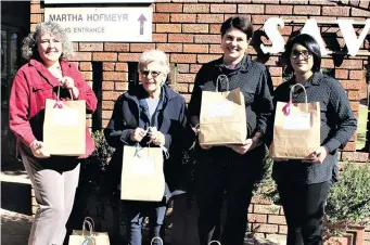  ?? ?? SAVF general manager Mariëtte Coetzer, Martha Hofmeyr Tehuis resident Babie Brits and Bolivia Estate staff members Chrezanne Dunkley and Charmain Govinden with some of the gift parcels.