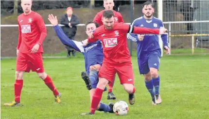  ??  ?? Glantraeth captain Kieren Jeffreys (red) wins this midfield tussle against Trearddur Bay