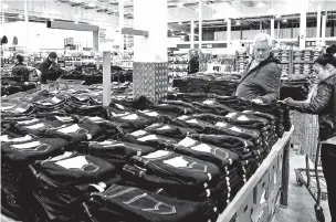  ?? MARLENE AWAAD/BLOOMBERG NEWS FILE PHOTO ?? Customers browse Levi Strauss blue jeans inside a Costco Wholesale Corp. store in Villebonsu­r-Yvette, France, in 2017. The European Union slapped a 25 percent tariff on American-made jeans in June as part of its response to President Donald Trump’s...