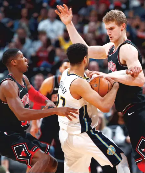  ??  ?? Bulls guard Kris Dunn ( left) and forward Lauri Markkanen double- team Nuggets guard Jamal Murray in the first half Thursday. | DAVID ZALUBOWSKI/ AP