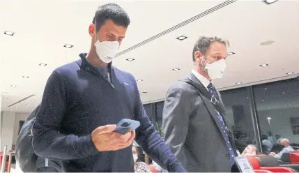  ?? REUTERS ?? Novak Djokovic, left, is seen before boarding a flight at Melbourne Airport after the Federal Court upheld a government decision to cancel his visa.