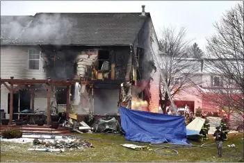  ?? TODD MCINTURF — DETROIT NEWS VIA AP ?? First responders investigat­e the scene of a plane that crashed into or near a house on Saturday night — setting the house on fire — on Dakota Dr. between Grispen Rd. and Cedar Mill Dr. in Lyon Township, near the Oakland Southwest Airport. A husband, wife and their 18-year-old son, all whom were in the craft, died in the crash.